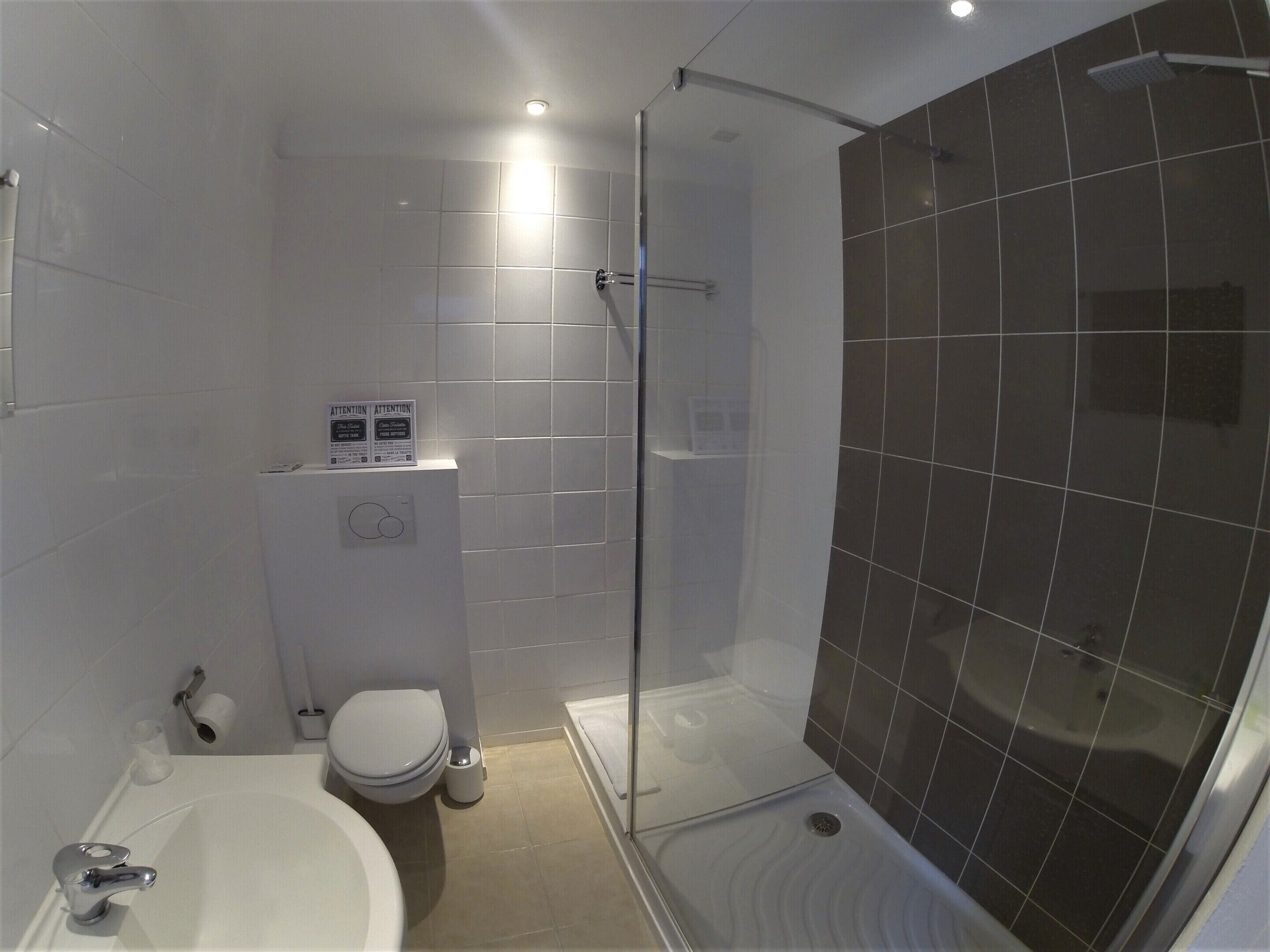Un baño con ducha, inodoro y lavamanos.