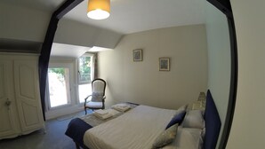 A bedroom with a bed, a chair, a window, and a door. - Auberge de la Sagne (Cabrerets)