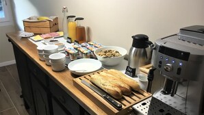 A breakfast buffet setup with various food items, a coffee machine, and a knife block. - Auberge de la Sagne (Cabrerets)