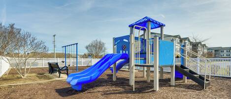 A playground with a blue slide and a small climbing structure.