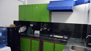 A kitchen with green cabinets, a water dispenser, a toaster, and a sink. - Nana Homes (Kathmandu)