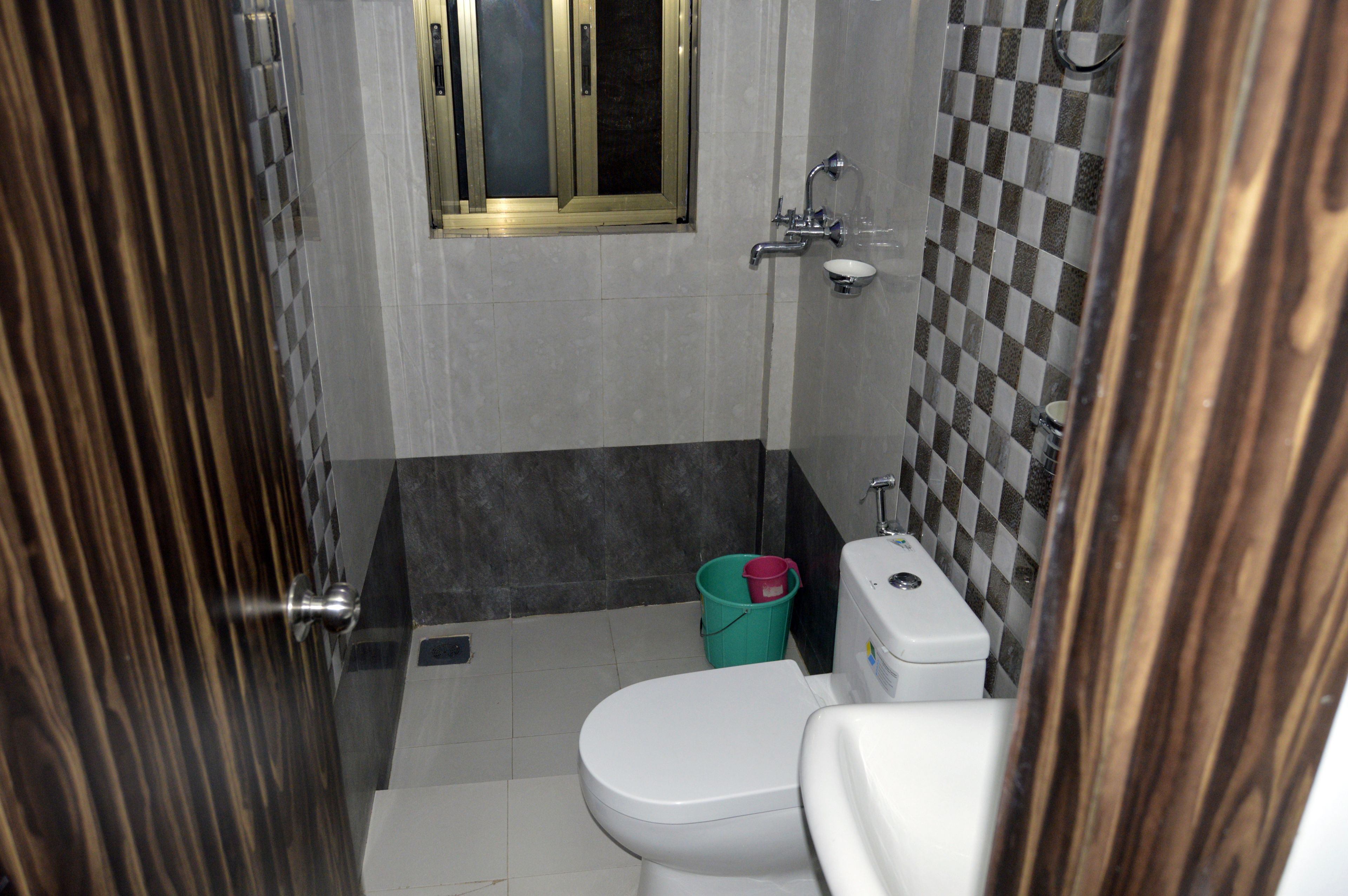 Un baño con inodoro, lavamanos y ventana.