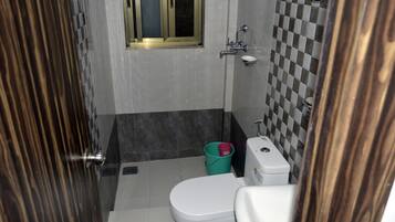 Un baño con inodoro, lavamanos y ventana.