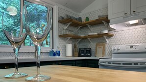 A kitchen with wooden countertops, a white stove, and a window with a view of trees. - The Red House - Eugenia - Beaver Valley, Ontario, Canada (Eugenia)