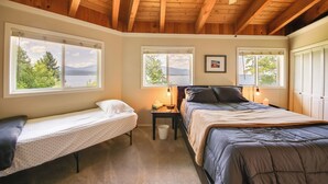 A bedroom with a wooden ceiling, two beds, and large windows offering a view of greenery and mountains. - 16 Mi to Schweitzer Mtn: Family Gem in Sagle! (Sagle)