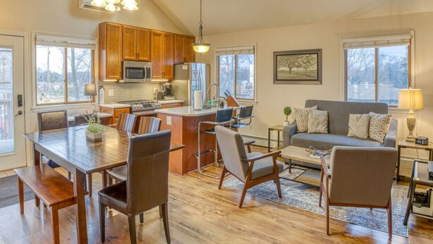 A spacious living area with a kitchen, dining table, and seating. - Elyon Hall CoachHouse, Indiana Dunes Nat’l Park, 10 min hike to Beach (Miller Beach)