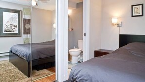 A hotel room with two beds, a bathroom, and a ceiling fan. - Charming, modern, private apt in the family-friendly Inner Richmond neighborhood; near GG Park. (San Francisco)