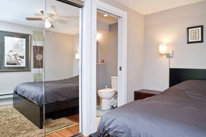 Une chambre d’hôtel avec deux lits, une salle de bain et un ventilateur de plafond.