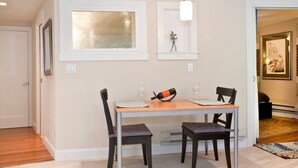 A dining area with a table and chairs, a pendant light, and a framed artwork on the wall. - Charming, modern, private apt in the family-friendly Inner Richmond neighborhood; near GG Park. (San Francisco)
