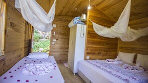 A wooden cabin room with two beds, each with a canopy, and a wardrobe. - Fullmoon Camping (Fethiye)