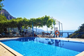 Una piscina al aire libre, tumbonas