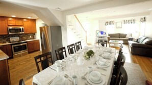 Een moderne keuken met houten kastjes, roestvrijstalen apparatuur en een eethoek gedekt voor een maaltijd.