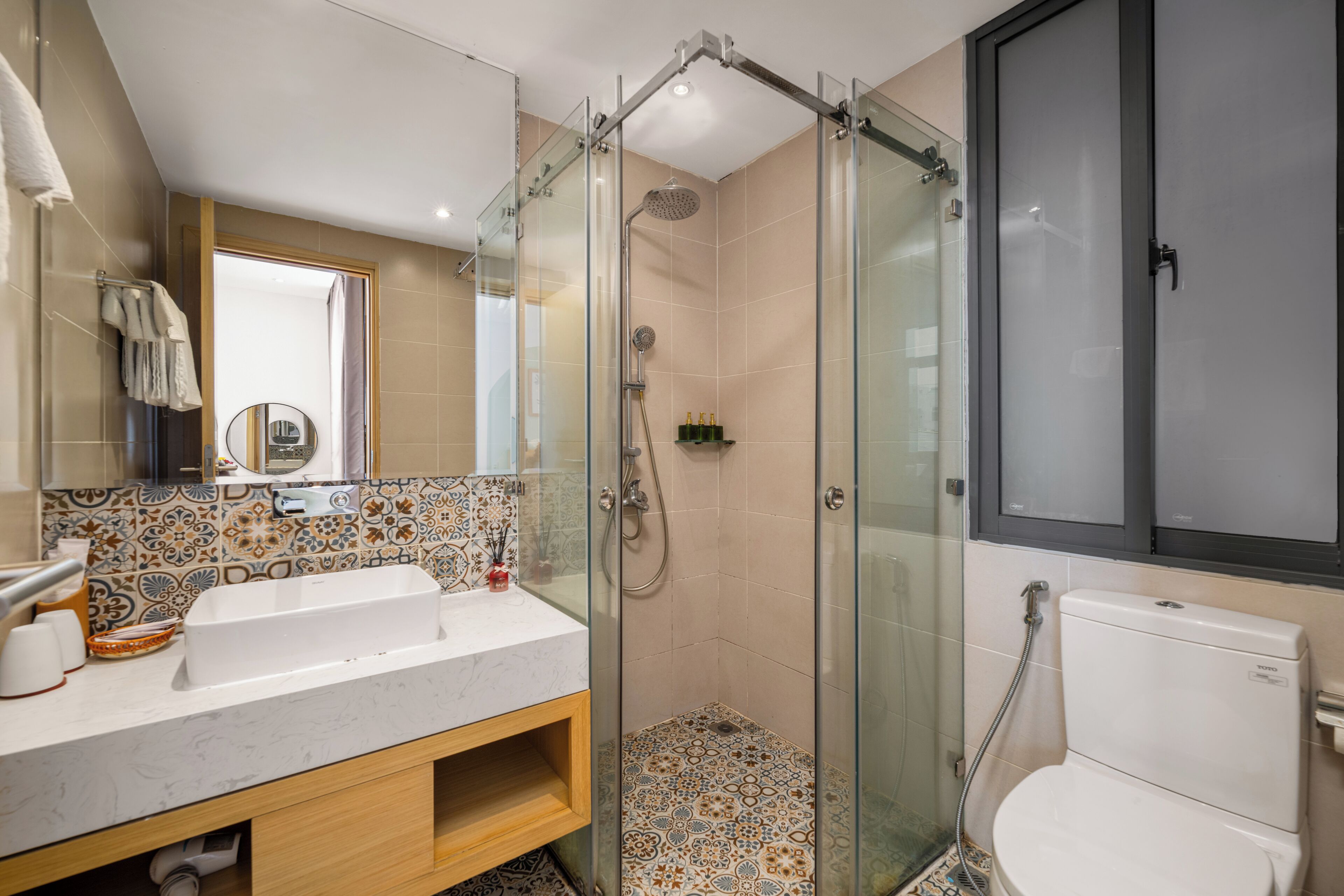 A modern bathroom with a glass-enclosed shower, a double sink vanity, and a toilet.