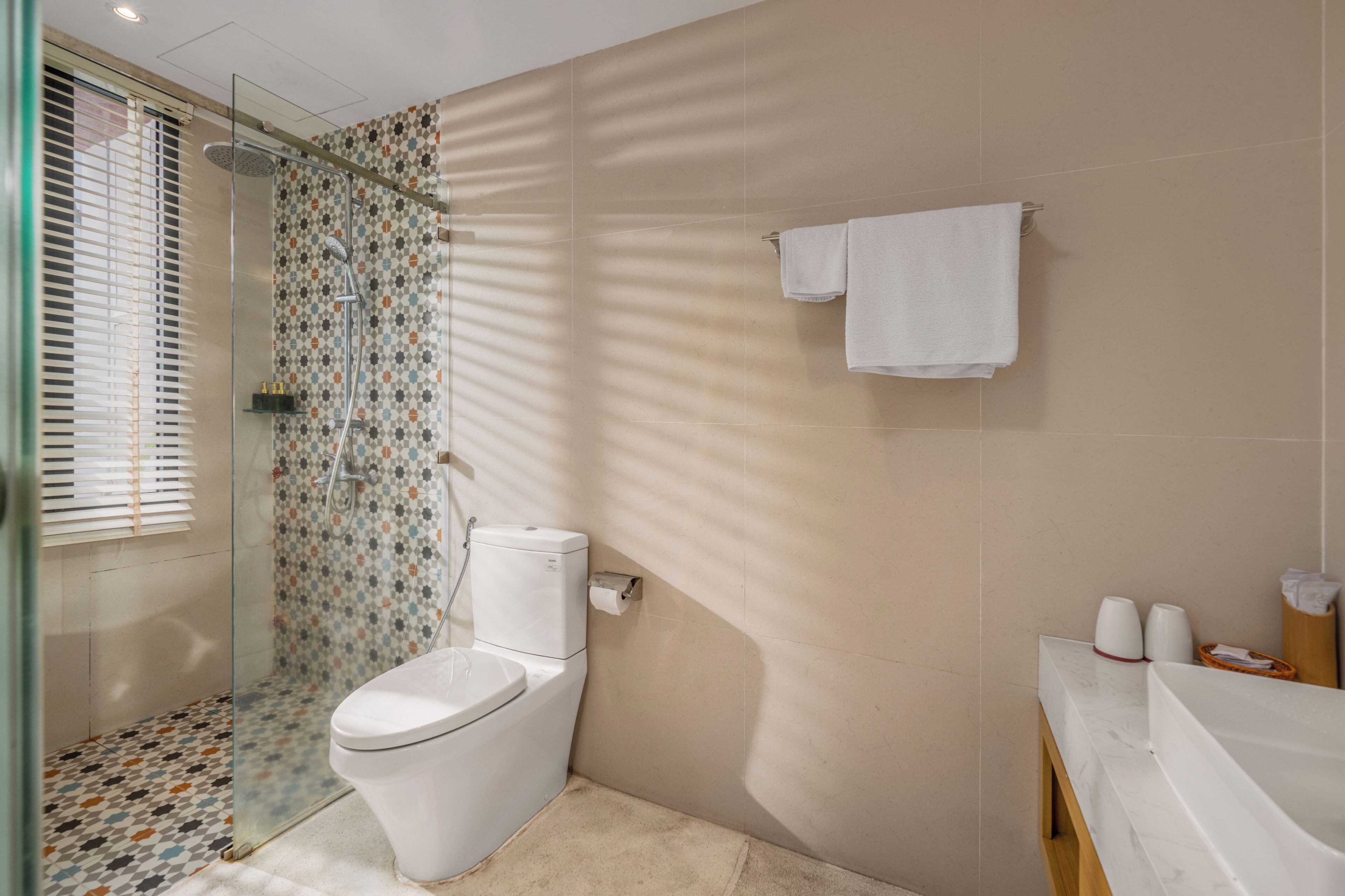 Een badkamer met een douche, toilet en wastafel.