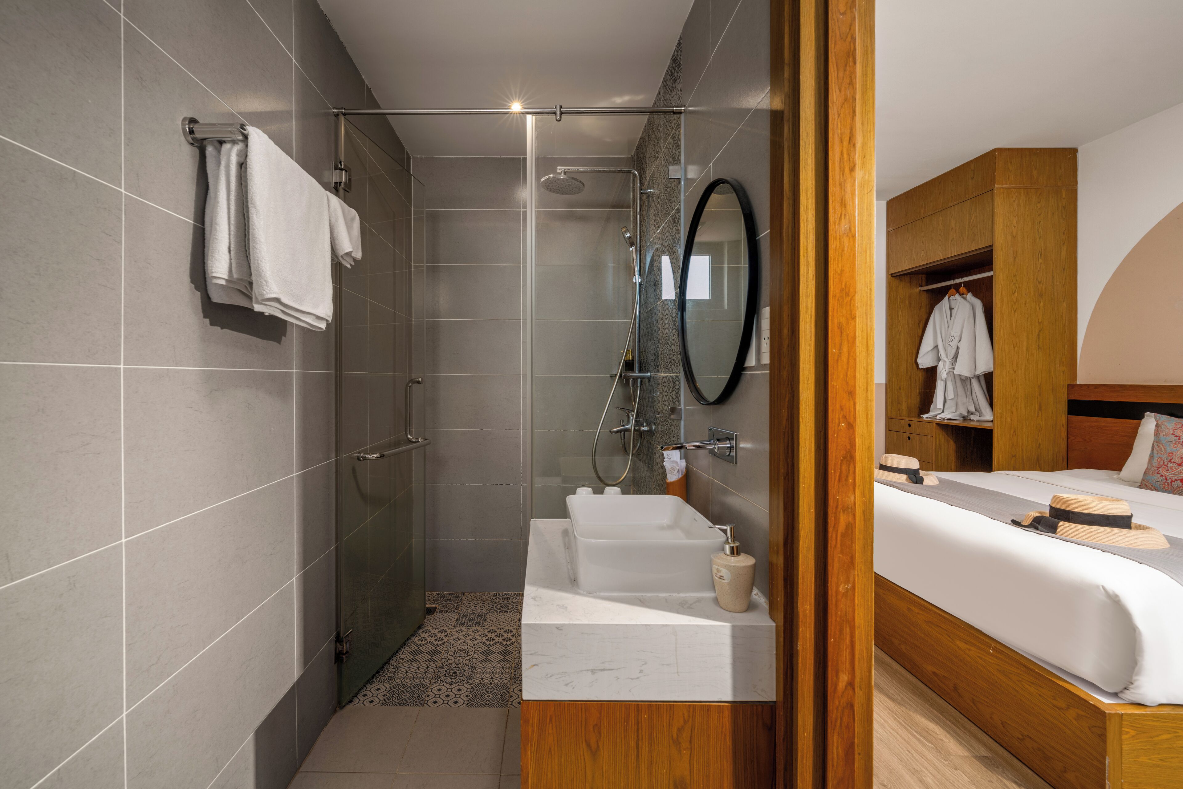 A modern bathroom with a glass shower enclosure, a white sink, and a wooden vanity.