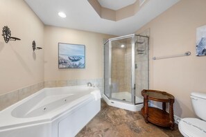 A bathroom with a bathtub, shower, and toilet.
