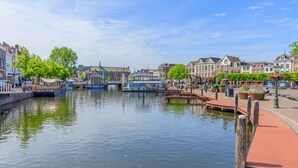 A canal with boats, a bridge, and buildings along the water. - LOT Hotel (Leiden)