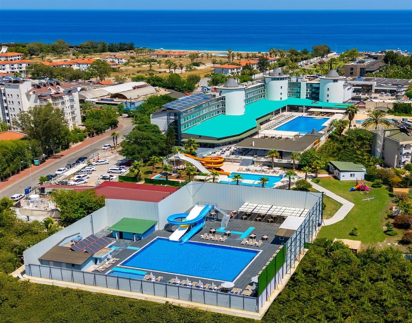Un resort con varias piscinas, parque acuático y vista al océano.