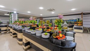 Monipuolinen buffet, jossa on tarjolla erilaisia ruokia ja koristeita.