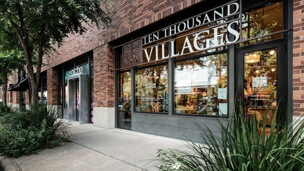 Un edificio de ladrillo con ventanas amplias y un letrero que dice "Ten Thousand Villages".