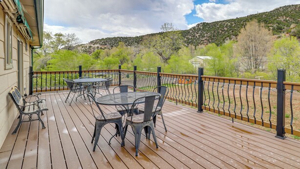 A wooden deck with outdoor furniture, a railing, and a view of a hilly landscape. - Mom's Place in Jemez - 1 Mi to Hot Spring (Jemez Springs)