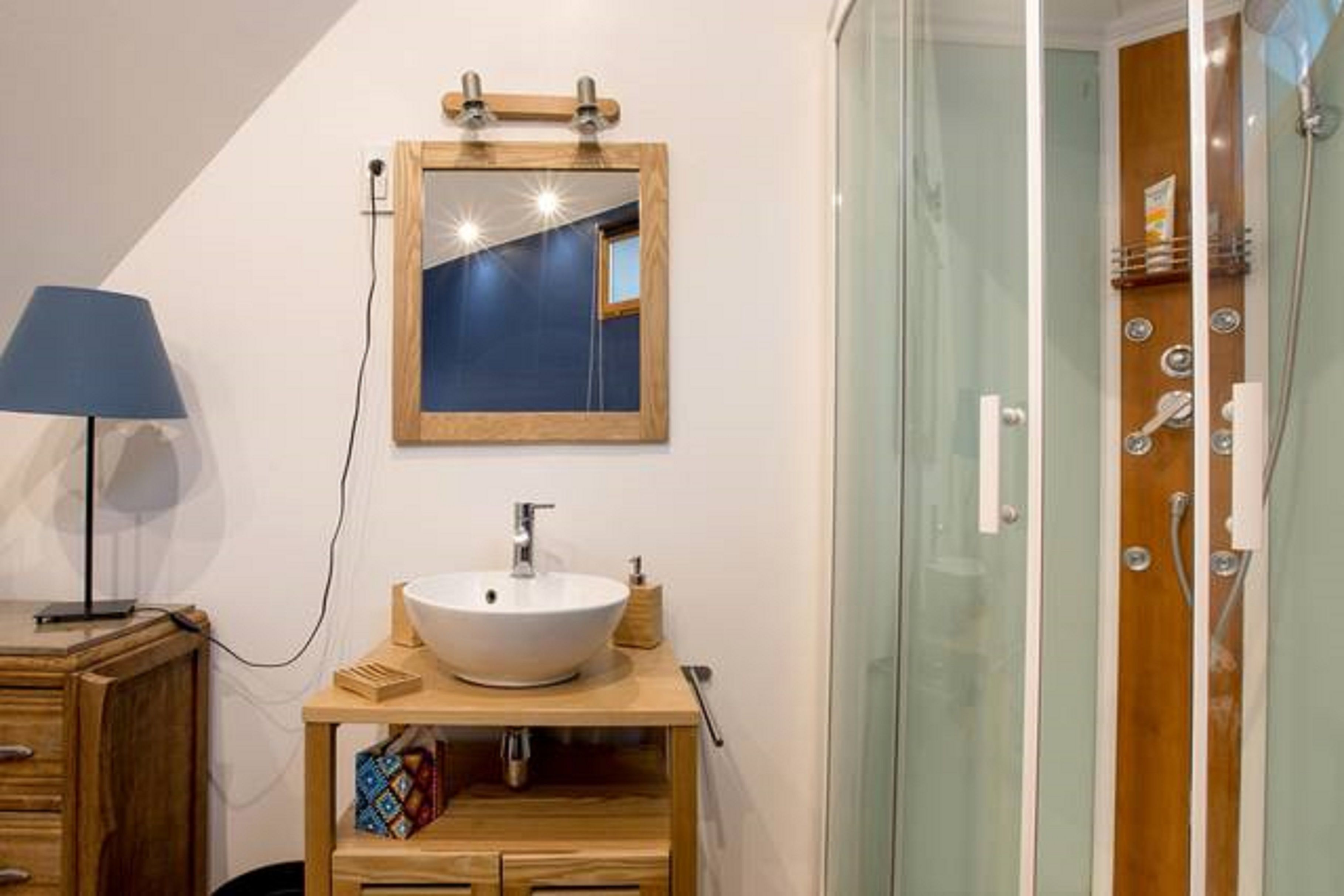 Un bagno con un mobile vanitario in legno, un lavandino bianco e uno specchio.