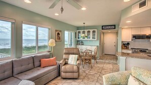 A spacious living area with a view of the ocean, a dining area, and a kitchen with white cabinets and a microwave. - Fernandina Beach Villa w/ Remarkable Ocean Views! (Fernandina Beach)