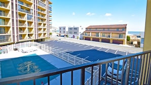 A hotel with multiple floors, a parking lot, and a view of the sea. - Seatime 303S-Oceanside 136th St, Free WiFi, Pool, Elev, W/D, AC (Ocean City)