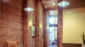 A reception area with a brick wall, wooden beams, and a curved reception desk. - Modern studio in the heart of the city (Seattle)