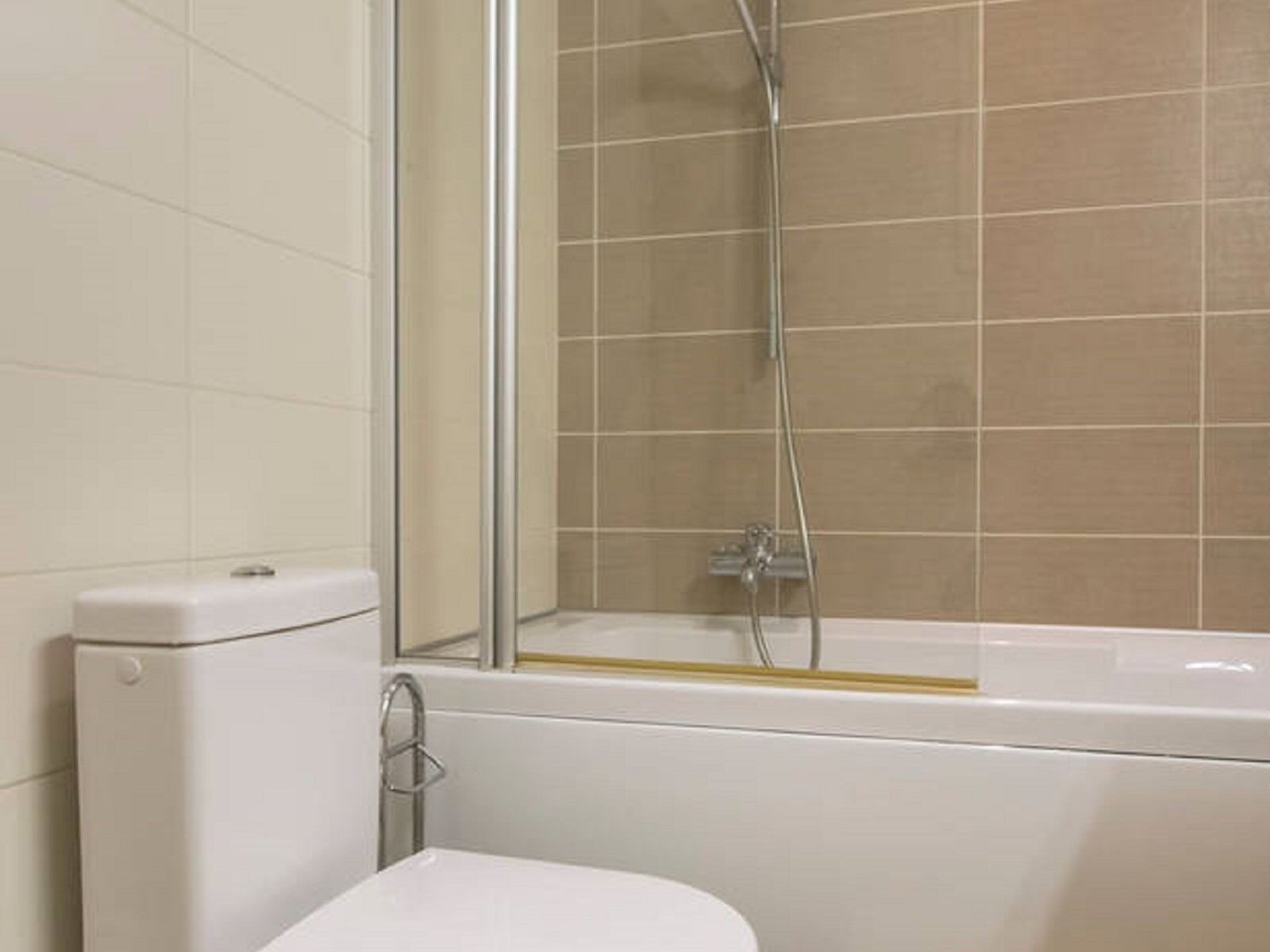 A bathroom with a toilet, a shower, and a bathtub.