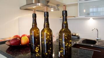 Three bottles with a light bulb inside on a kitchen counter.