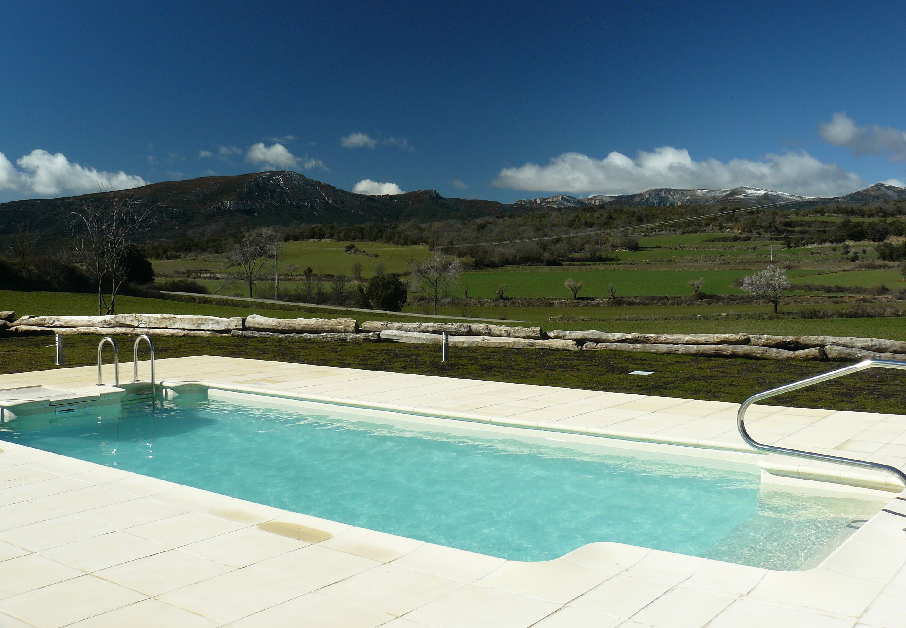 A swimming pool with a view of mountains and a clear sky.