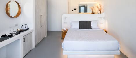 A modern bedroom with a bed, bedside table, and a mirror.