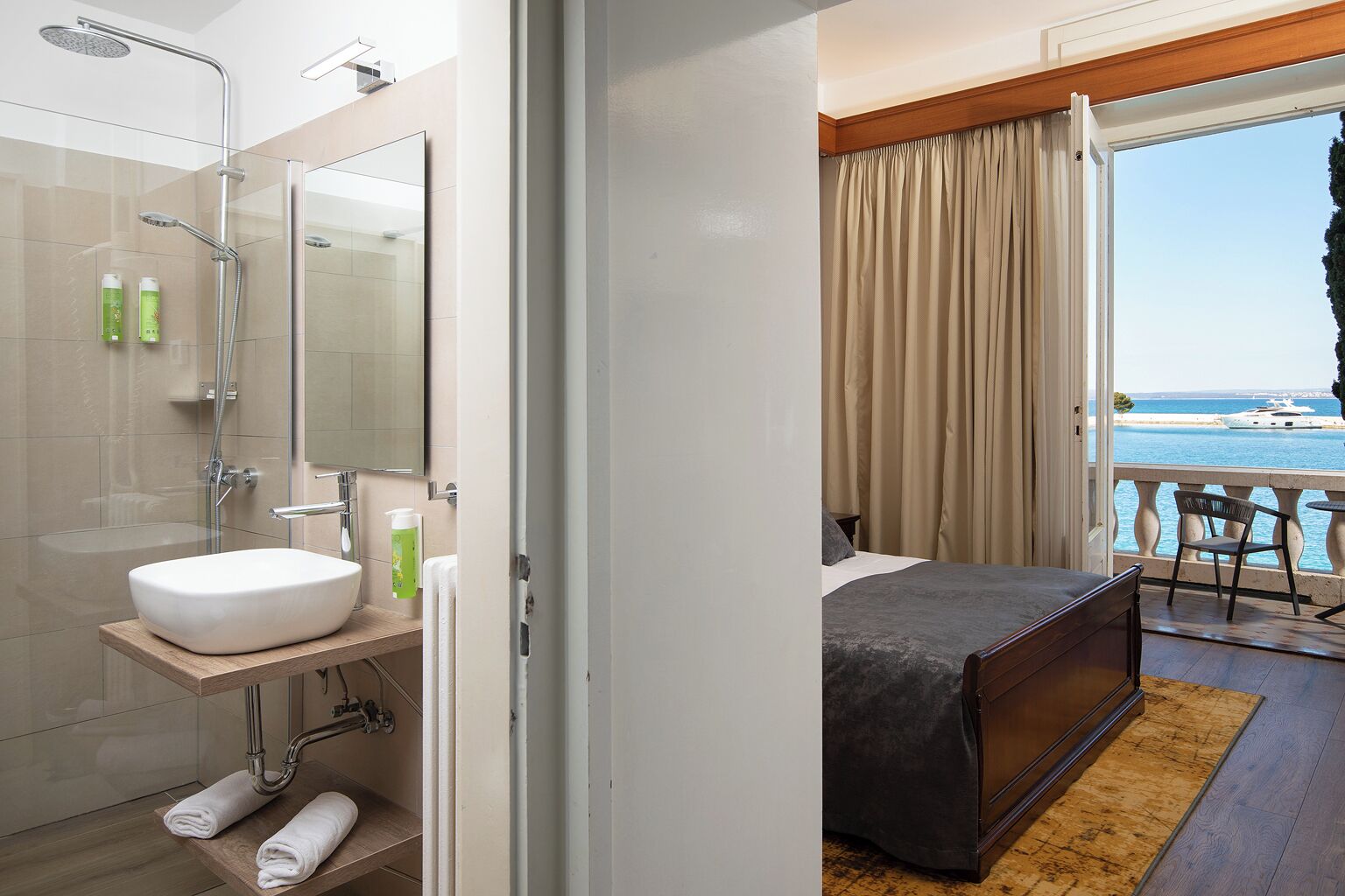 A modern bathroom with a glass shower enclosure, a white sink, and a wooden vanity.