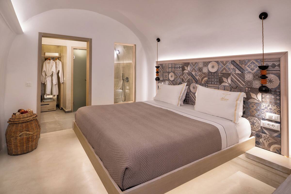 Quarto moderno com uma cama grande, um closet espaçoso e cabeceira estampada.