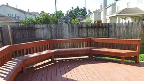 Eine Holzterrasse mit einer gebogenen Bank.