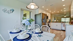 A modern kitchen with white cabinets, a built-in oven, and a large island with a sink. - Coastal Condo, Heated Pool Steps from the Beach (Holmes Beach)