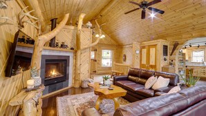 Ein gemütliches Blockhaus-Interieur mit Kamin, Ledersofas und rustikalem Dekor.