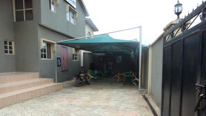 A courtyard with hexagonal tiles, a motorcycle, and outdoor furniture.