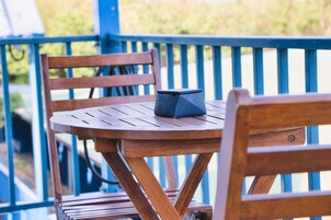 Una mesa de madera con un objeto negro encima, colocada sobre una barandilla azul.