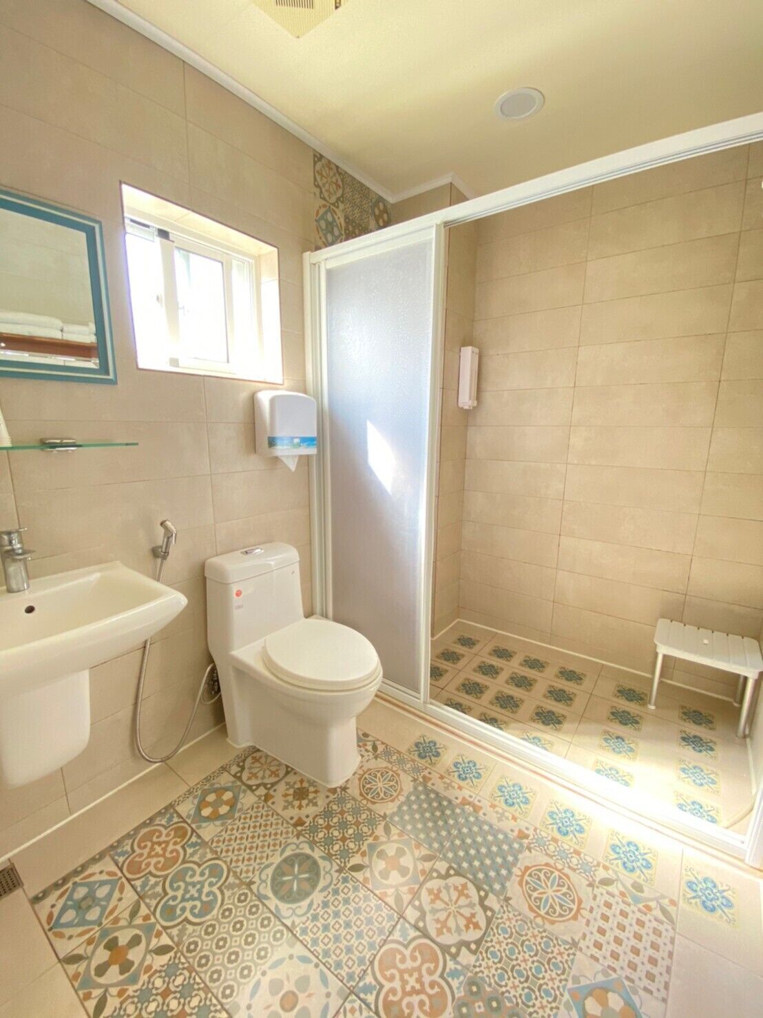 A bathroom with a toilet, sink, and shower area.