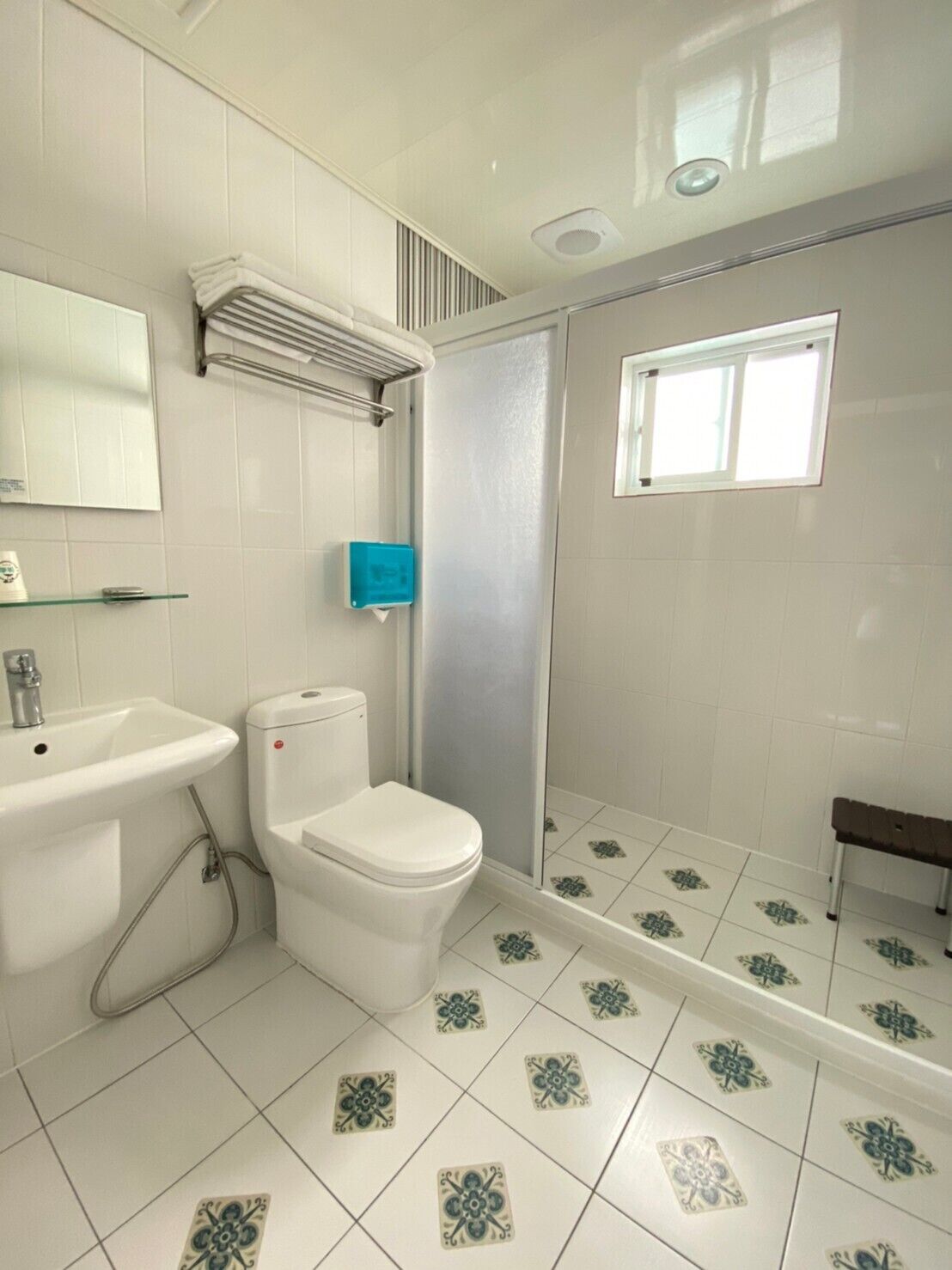 Une salle de bain avec des toilettes, un lavabo et une douche.