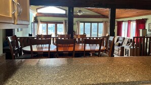 Une cuisine dotée de plans de travail en granit, de meubles en bois et d’un coin repas avec une table et des chaises.