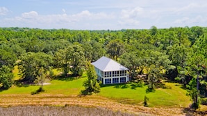 A modern house surrounded by dense forest.