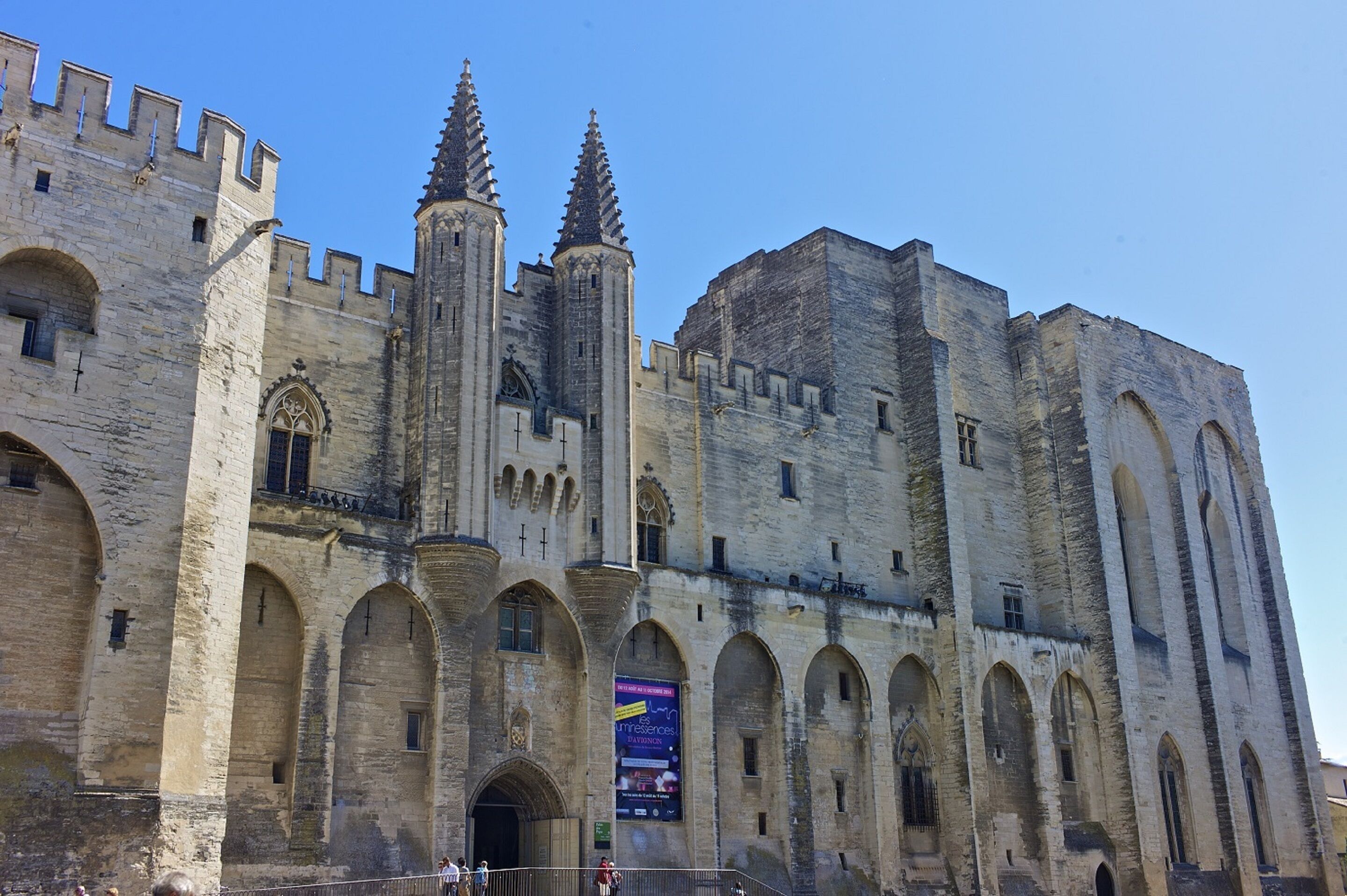 Un bâtiment historique en pierre, doté de fenêtres en arc et d’une tour imposante.