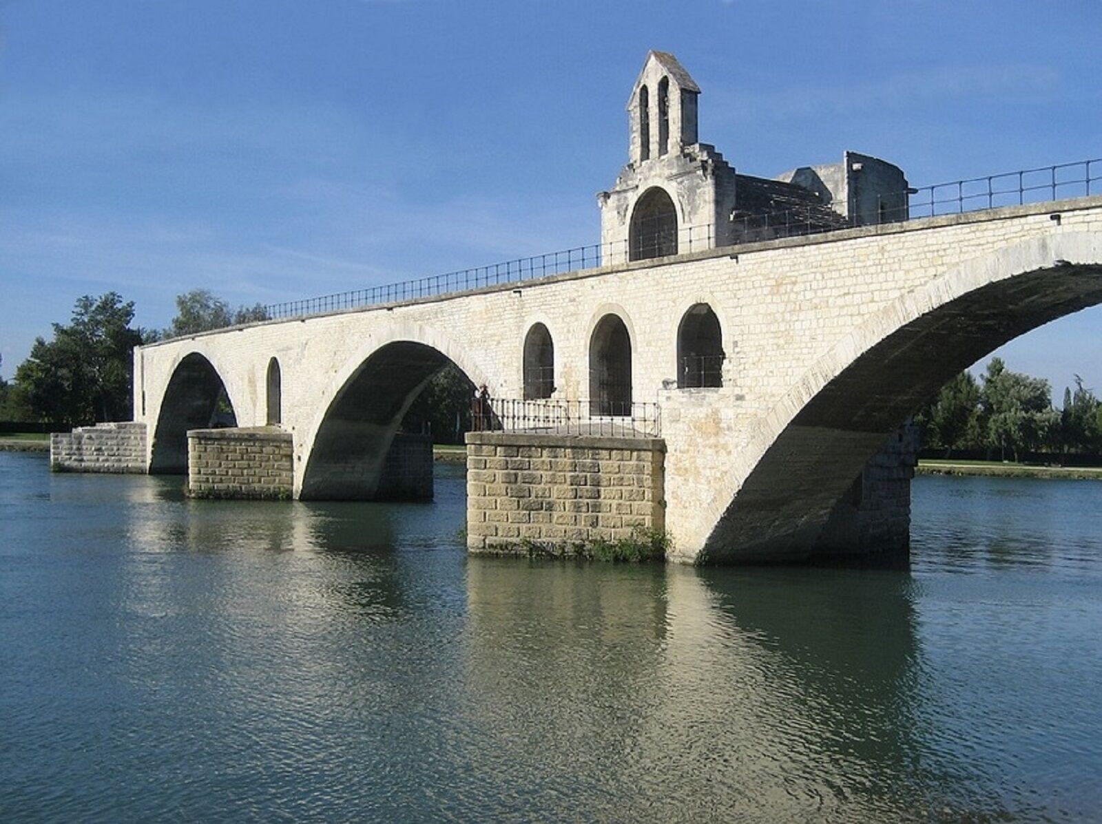 A stone bridge with multiple arches over a body of water.