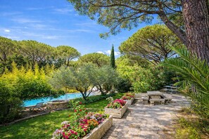 A garden with a pool, stone benches, and a variety of plants. - La Bastide Des Pins (Castillon-du-Gard)