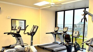 A gym with treadmills, stationary bikes, and an elliptical machine.