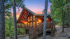 A rustic cabin with a wooden exterior, a balcony, and a staircase leading to the entrance. - Sevierville Cabin w/ Deck: Minutes to Pigeon Forge (Sevierville)