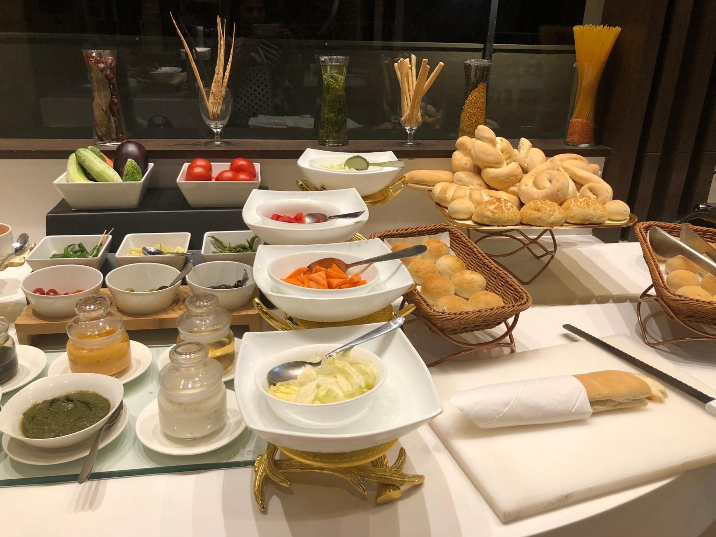 A buffet table with various food items and condiments.